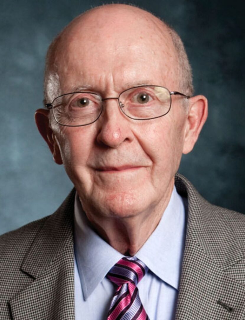 A man in glasses and suit with tie.