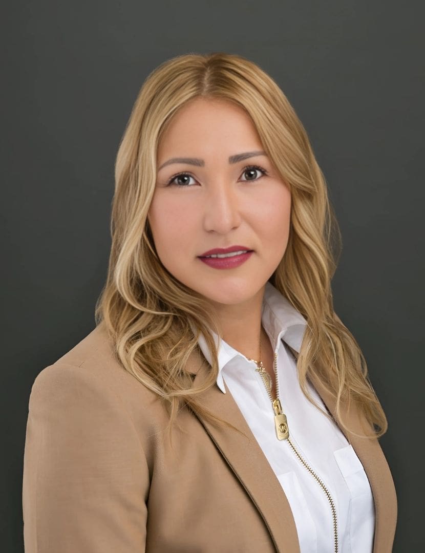 A woman in a brown jacket and white shirt.