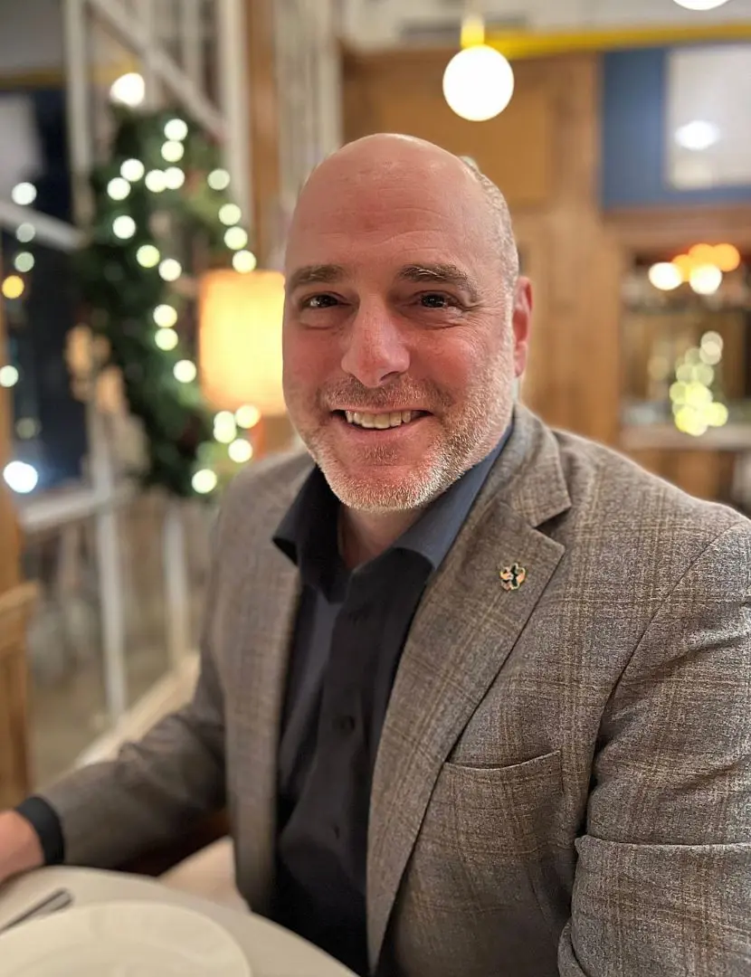 A man in a suit and tie smiling for the camera.